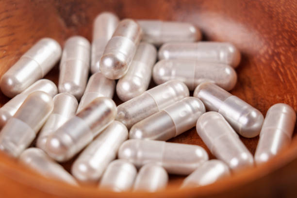 istock Vitamin natural supplement pharmaceutical capsules in a wooden container 1495712720