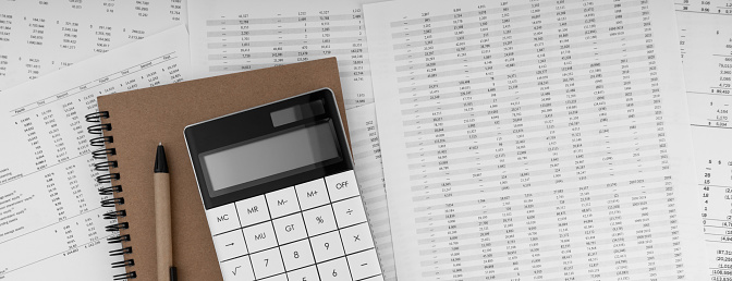 Calculator with notebook on financial statement.