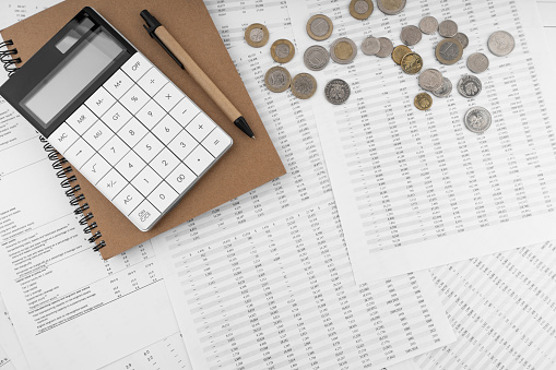 Calculator on financial statement and coins