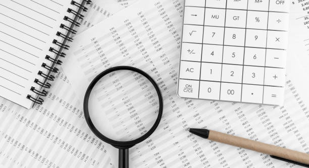 istock Calculator, magnifying glass, pen lying and notebook on financial statement. Financial concept. Top view. 1495715142