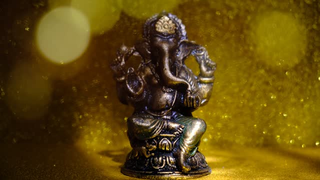 Deity of Ganesha on beautiful golden background and glare lights