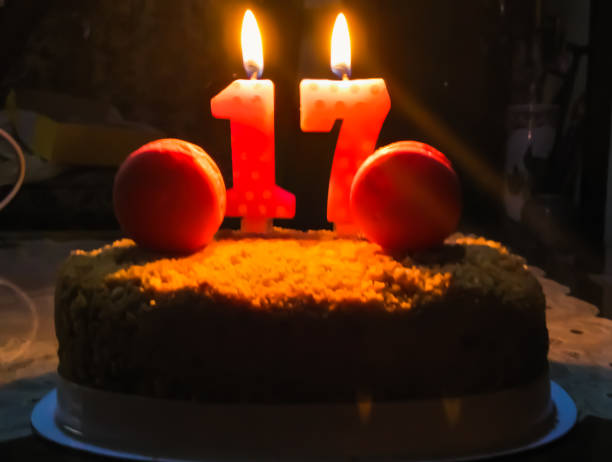 istock Birthday cake with number 17 candles light in the dark background. 1495722096