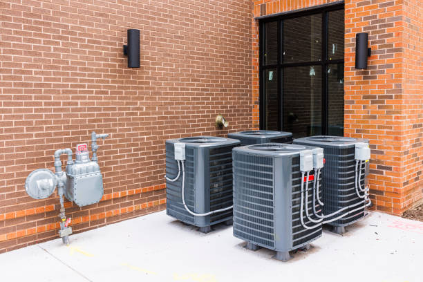 Air conditioning sets and gas meter near a brick wall. Mini air cooling chillers and heat pumps near the window stock photo