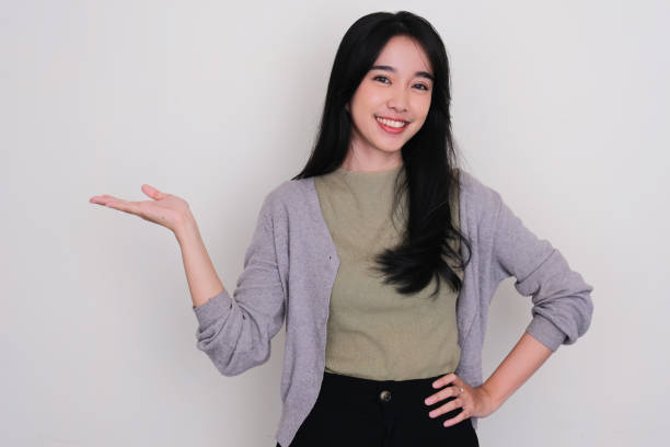 istock Young Asian women smiling with one hand holding something pose 1495763732