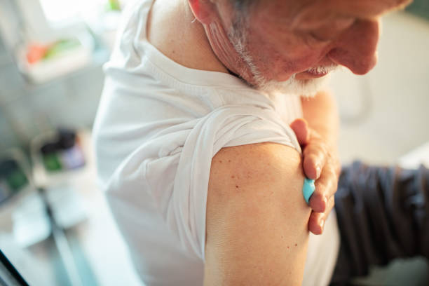 istock Senior man putting medical cream on his shoulder 1495766334
