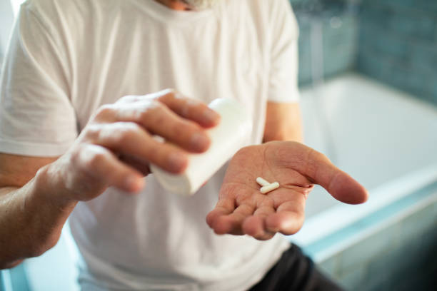 istock Senior man taking a pill in a bathroom 1495766388