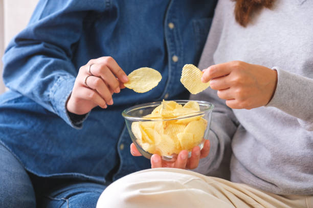 istock Closeup image of friends sharing and eating potato chips together 1495767821