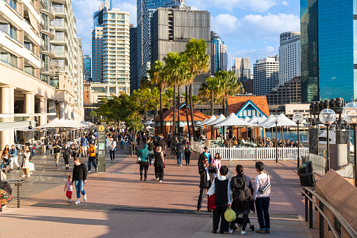 Crowd of people at Circular Quay Sydney. With the CBD buildings in the background.