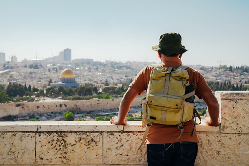 asian man man standing at The Old Town with the Dome of the Rock at the sunset from Mount of Olives