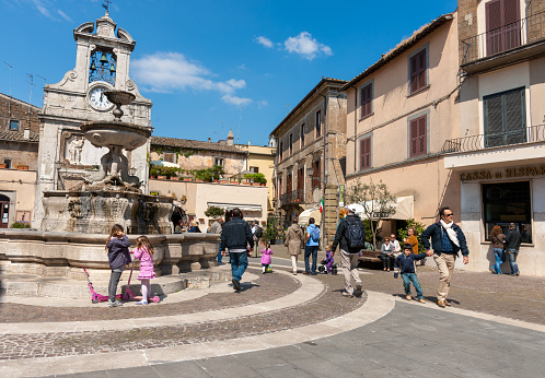 Sutri Italy -  April 17 2011; Typical ancient Italian town square with people on sunny morning