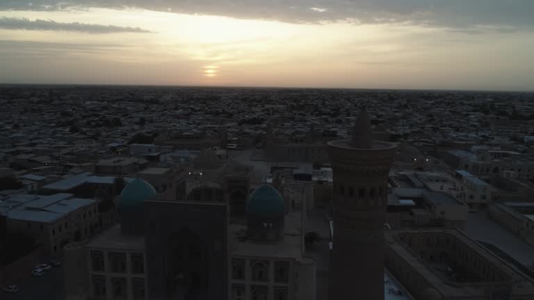 A drone flies around the famous memorial complex Kalyan Poi Kalon Complex and Poi Kalon Minaret, Poi Kalan or Po-i-Kalyan in Bukhara at dawn