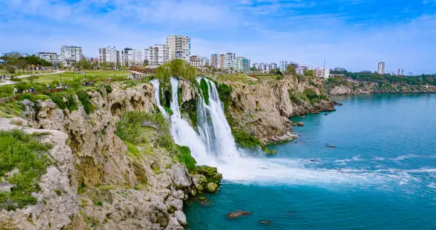 Photo of Duden waterfall dropping in Mediterranean Sea in Antalya, Lara Antalya in a bright sunny day, Lower Duden Waterfalls, high waterfall pouring into the sea, the waterfall in the city falls into the sea, turkey's famous tourism destination, the highest water
