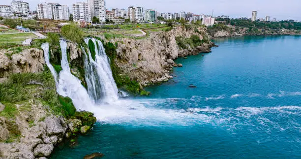 Photo of Duden waterfall dropping in Mediterranean Sea in Antalya, Lara Antalya in a bright sunny day, Lower Duden Waterfalls, high waterfall pouring into the sea, the waterfall in the city falls into the sea, turkey's famous tourism destination, the highest water