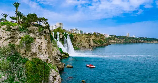 Photo of Duden waterfall dropping in Mediterranean Sea in Antalya, Lara Antalya in a bright sunny day, Lower Duden Waterfalls, high waterfall pouring into the sea, the waterfall in the city falls into the sea, turkey's famous tourism destination, the highest water