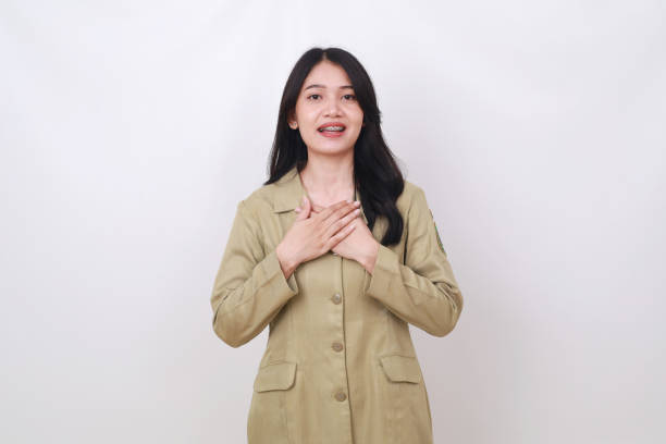 istock Relieved young indonesian civil servant employee standing while holding her chest 1495793562