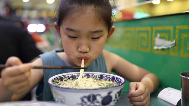 Little girl eating ramen noodles