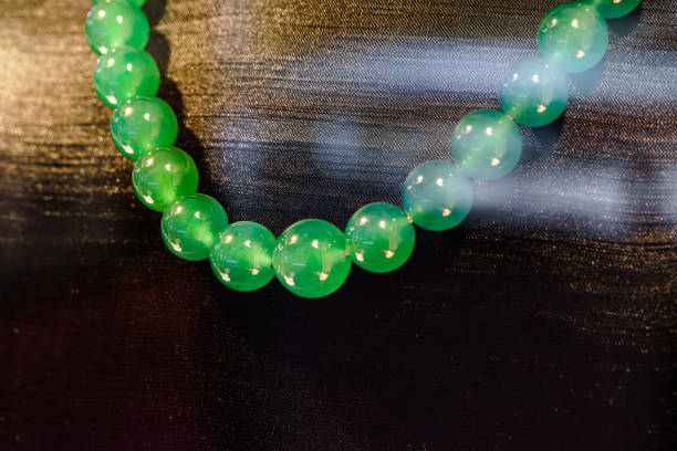 String of round beads from green nephrite stone String of round beads from green nephrite stone emerald green bracelet stock pictures, royalty-free photos & images