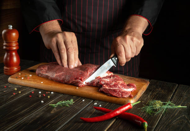 istock The chef cuts raw fresh beef meat on a cutting board before baking or grilling. Working environment in the kitchen of a restaurant or hotel. 1495807751
