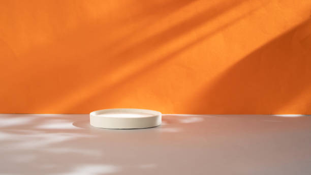 white round concrete podium on orange background with shadows - close up shiny merchandise rough imagens e fotografias de stock