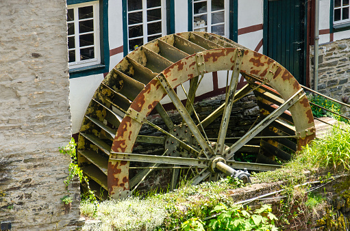 Monschau, Germany, May 25, 2023: old and somewhat rusty steel water wehhel in the old town