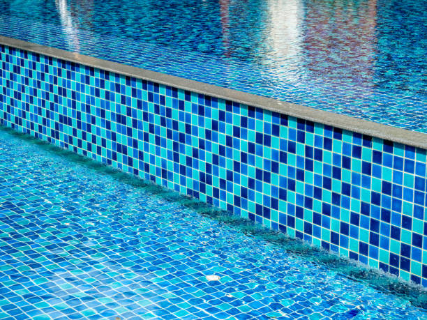 屋外スイミングプールの背景に壁と床に青のモザイク装飾のモダンなスタイル。プールの端にある正方形のタイルで、清潔で澄んだ水で高い階段があります。 - swimming pool residential structure style steps ストックフォトと画像