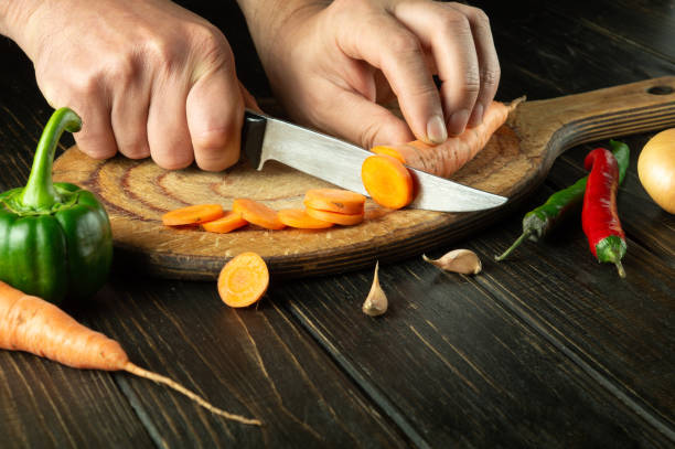 istock The cook cuts carrots on a cutting board for preparing a vegetarian lunch or breakfast. Delicious healthy food 1495813517