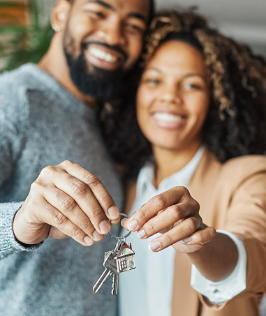 Happy young couple buying a new house receiving the keys