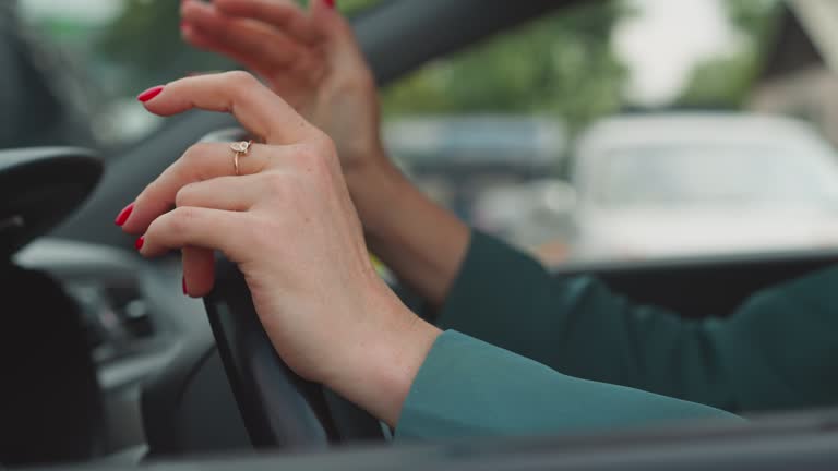 Angry woman hits steering wheel of automobile with hands