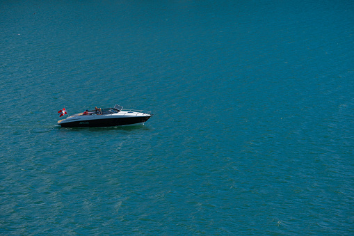 Brockville, Ontario, Canada; July 3, 2016. Two people in a speedboat on the St. Lawrence River under a cloudy blue sky during a Poker Run event