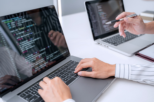 Programmer Writing Program Code With Two Monitors And Working On A New ...