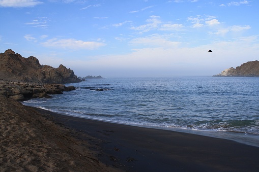 A scenic beach with a tranquil, unpopulated rocky shoreline. Peru.