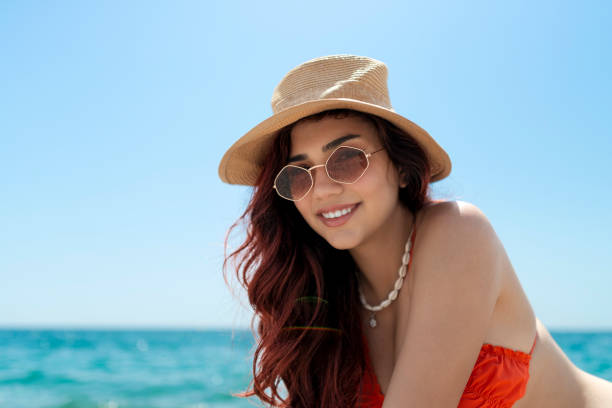 istock Happy smiling woman sitting at beach. 1495847667