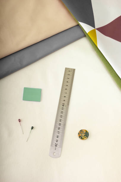 istock Ruler, chalk and other tailor's tools against the background of fabric cuts. View from above 1495852733