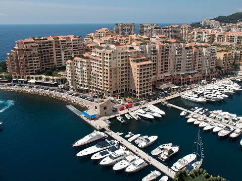 Monaco, France – July 07, 2017: A picturesque view of a harbor with several docked boats and tall buildings and multi-story apartments on the edge