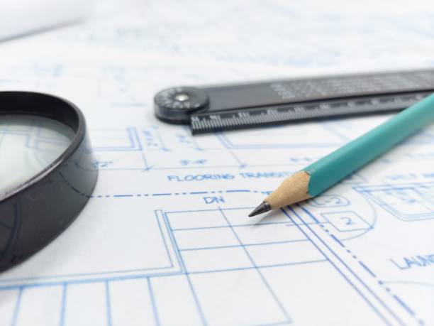 istock Image of blueprints with level pencil, ruler and magnifier on table 1495853096