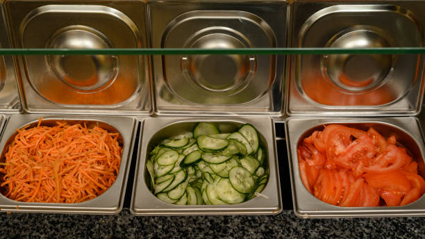 istock Dishes for ready-made chopped vegetables on the surface of a work table in a fast food restaurant 1495854663