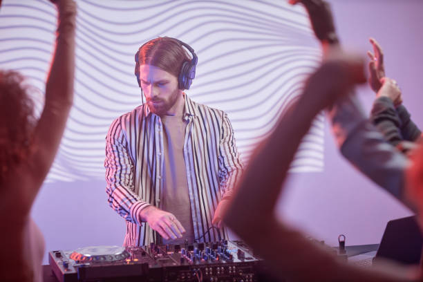 istock Long haired DJ by turntable in neon lights 1495866451