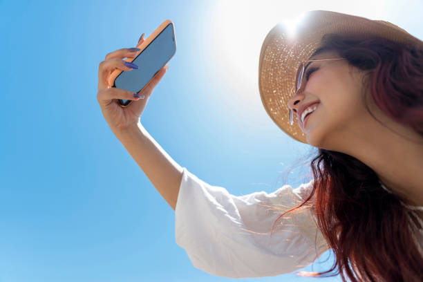 istock Young girl using mobile on the beach. 1495867291