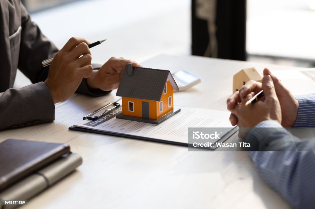 Real estate agent discuss about the terms of the home purchase agreement and asked the customer to sign the documents to make the contract legally, Home sales, lease, mortgage and home insurance. Will - Legal Document Stock Photo