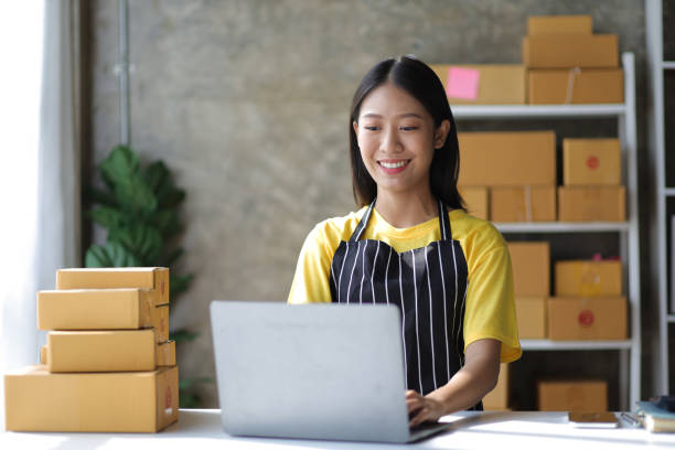 istock Young small business entrepreneur working with laptop and parcel boxes preparing for delivery. 1495874766