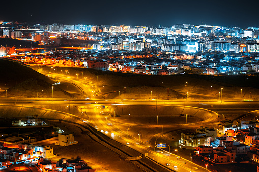 Aerial view of the night city of Muscat - the capital of the Sultanate of Oman. Road junctions and houses illuminated at night