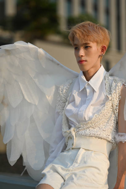 mode portrait en verticale avec un adolescent attrayant dans une élégante tenue blanche et des ailes d’ange. - coupe en dégradé photos et images de collection