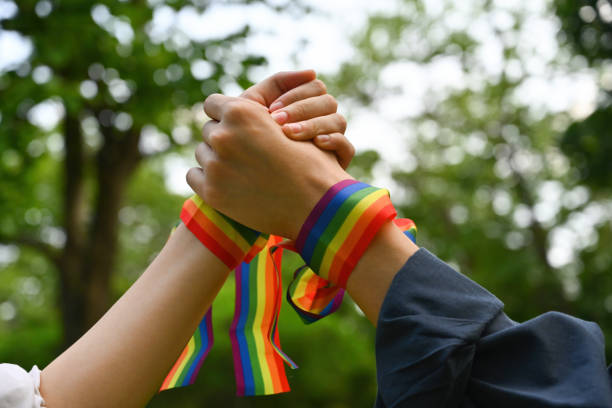 istock A hands with rainbow wristband holding and joining hands together, Support and celebrate the LGBT community. 1495887613