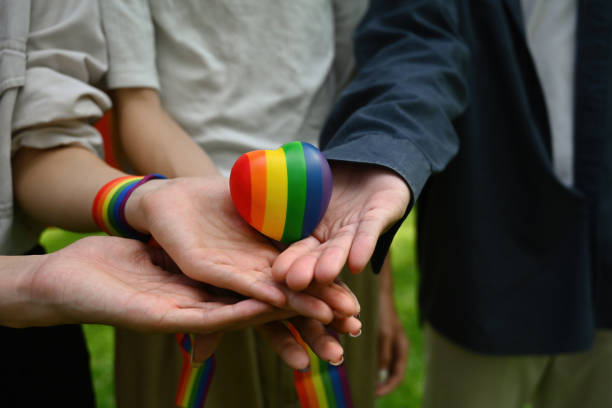 무지개 하트 모델을 함께 들고 있는 손 그룹, 심장 모델에 초점을 맞추는 것, lgbt 프라이드의 달의 개념. - gay pride wristband rainbow lgbt 뉴스 사진 이미지