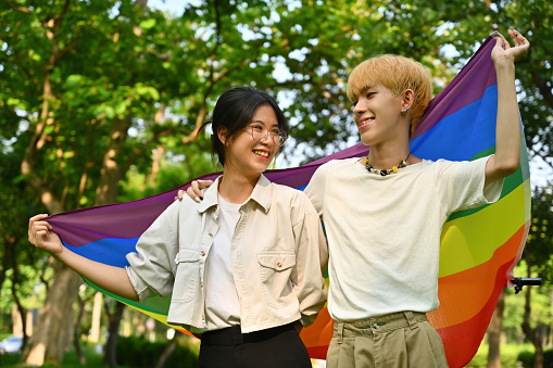 Portrait with Young LGBT teenagers holding pride flag together, Celebration Pride month concept.