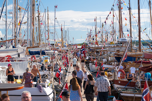 Oslo, Norway - July 19 2014: People looking at old wooden boats in a marina.
