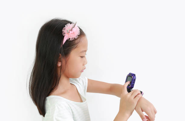 istock Little Asian girl kid using smart watch video camera against white background 1495889251