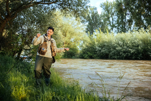 Male fisherman prepares a fishing rod