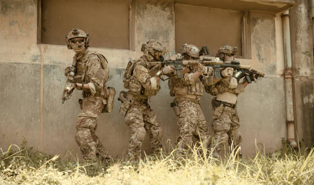 istock Professional marine soldiers training with weapon on a military range. 1495895269