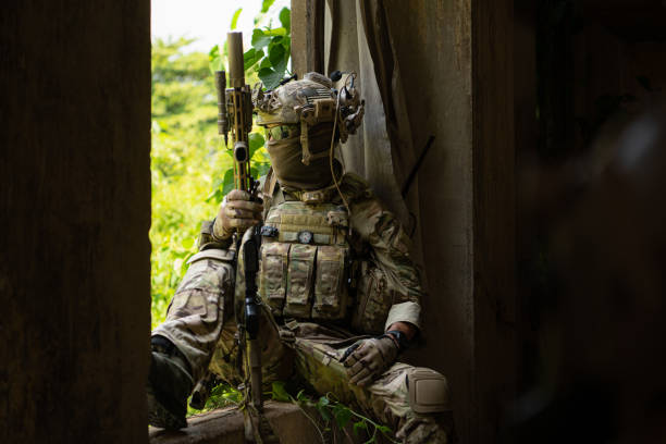 istock Special forces soldier in camouflage, Take refuge in an abandoned building before starting a new patrol operation. 1495895435